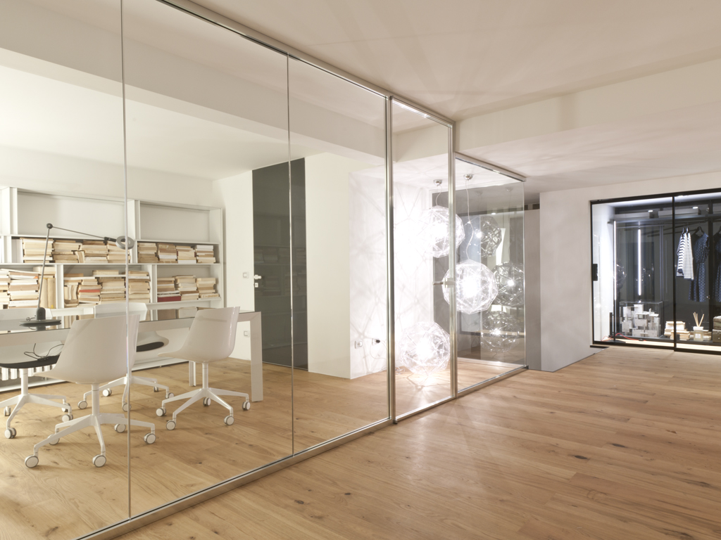 Al piano interrato dello showroom Albed a Milano, la parete modulare Vista ufficio. L'illuminazione è Martinelli Luce