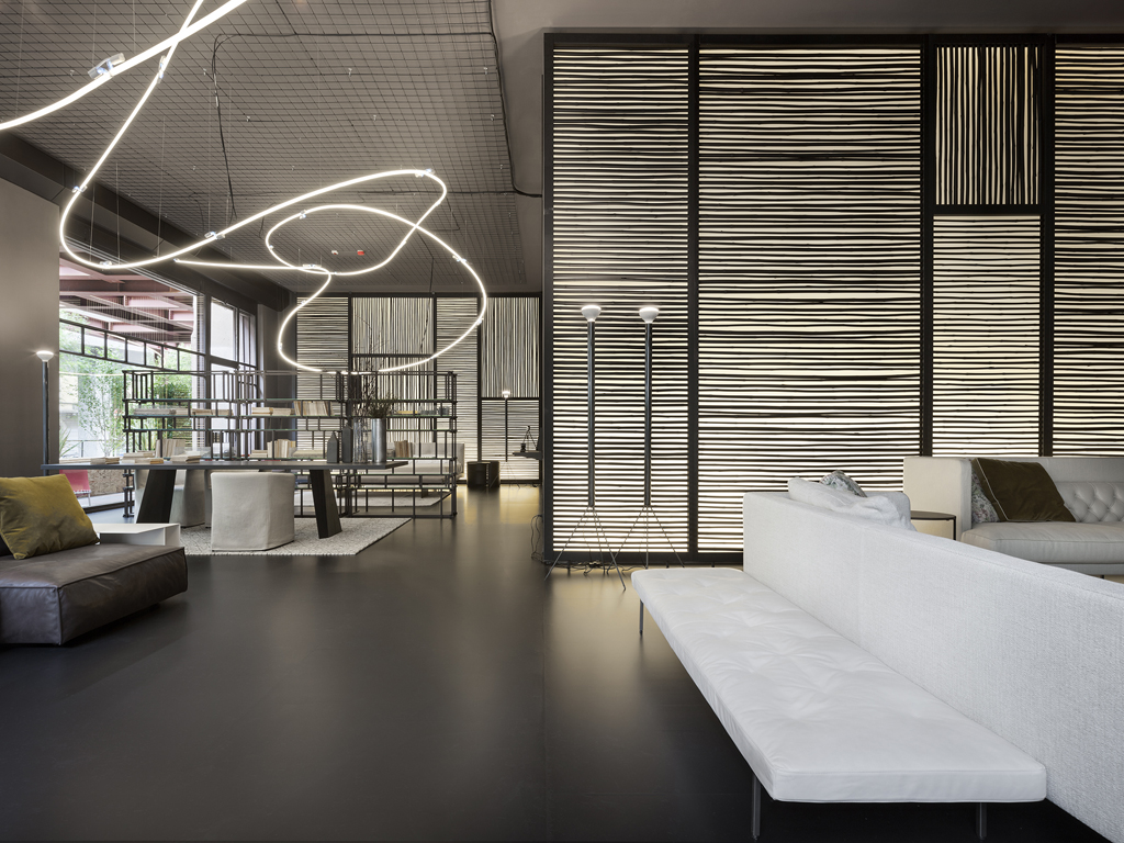 Living Divani. Quattro diverse ambientazioni da casa da sogno, realizzate con il contributo di Kerakoll per le finiture e di Flos per l’illuminazione, il Living Divani Temporary Store Torre Velasca progettato da Piero Lissoni è un sofisticato rifugio contemporaneo, dove una scultura luminosa di neon al soffitto, tributo a Lucio Fontana, sembra assorbire le energie e le tensioni della città donando inaspettati momenti di relax. (ph Santi Caleca)
