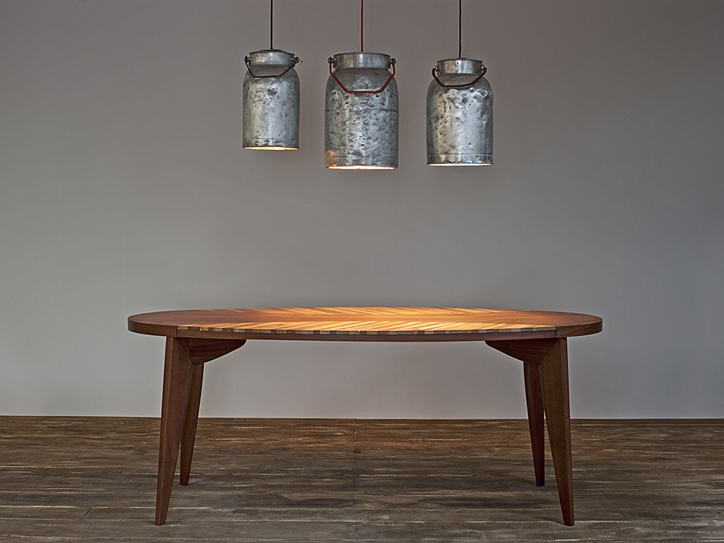 TheChicFish. Tavolo Ovale Vintage, in legno massello di mogano, design anni '70. Il piano è un mix di essenze legnose. Progetto dell'architetto Antonio Candussio (Euro 2.600). Sovrasta il tavolo la Lampada Latte. I contenitori di latte originali sono dei primi del Novecento (Euro 190.00).