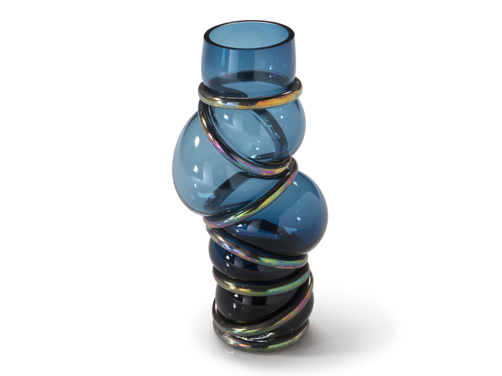 Natuzzi Italia. Vaso Chain Ring. Forma irregolare e accattivante per questo vaso in vetro soffiato, impreziosito da anelli di metallo. Colori: blu navy e viola gioiello.