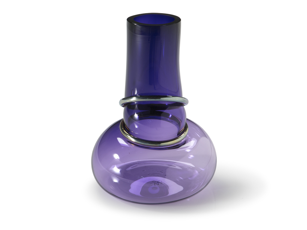 Natuzzi Italia. Vaso Double Ring. Forma irregolare e accattivante per questo vaso in vetro soffiato, impreziosito da anelli di metallo. Colori: blu navy e viola gioiello.