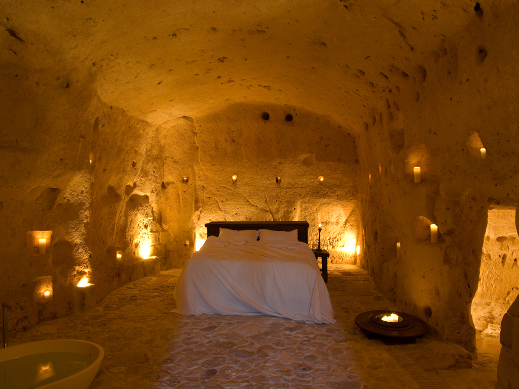 Sextantio Albergo Diffuso Le grotte della Civita. Grotta 14 Suite. 70 mq., la vasca è posizionata a fianco del letto