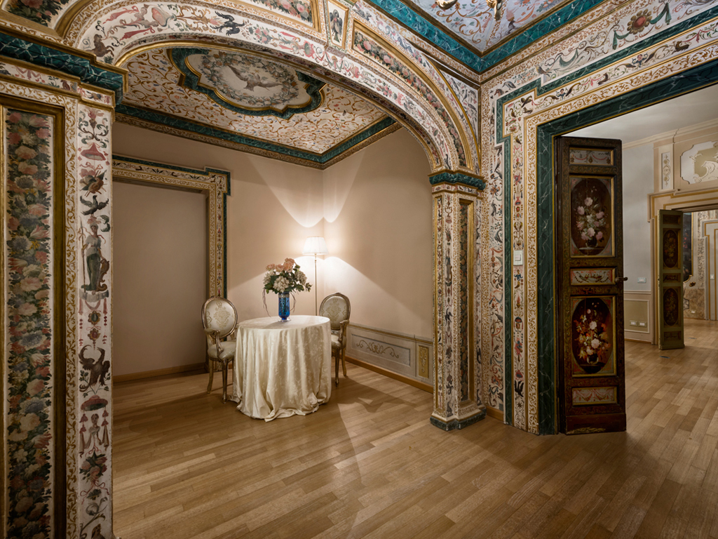 Hotel Alla Posta dei Donini. Sala Alcova. Il piano nobile, ristrutturato nella metà del Settecento, conserva tuttora la classica infilata di salotti impreziositi da porte e tele dipinte da Nicola Giuli nel 1780.