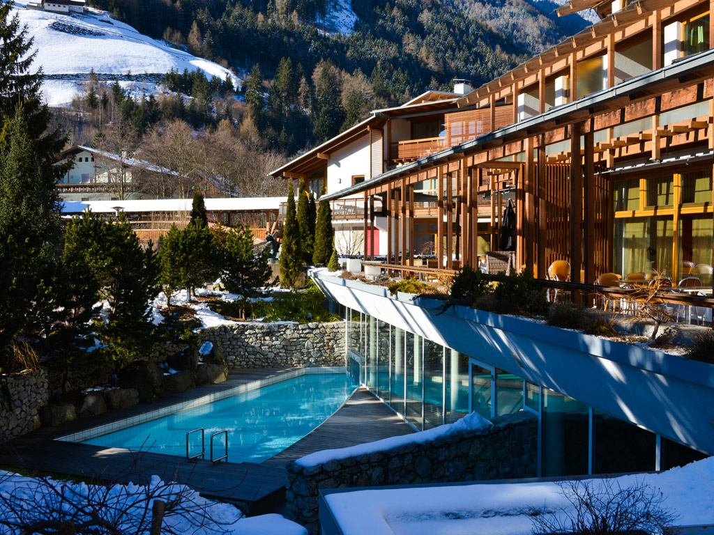 feldmilla.designhotel. Una veduta esterna dell'hotel che si trova nella Valle Aurina. Solo un piccolo ponte, che attraversa il fiume Aurino, separa la struttura dal centro di Campo Tures.