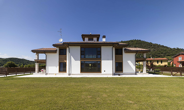 Rubner Haus. Casablanca Blockhaus. Abitazione Vedica. L’esterno della casa ad intonaco è sobriamente articolato nei volumi e si raccorda con il giardino tramite due porticati simmetrici.