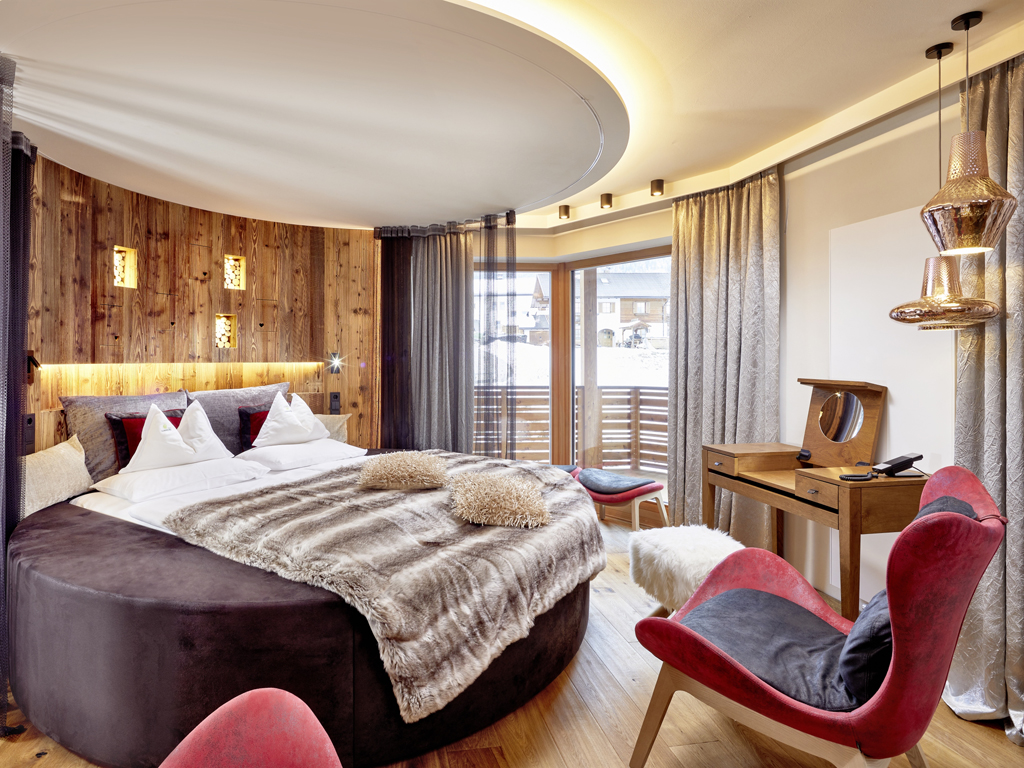 Hotel Quelle Nature Spa Resort. La Camera Romantic Fire (40mq.), arredamento in legno di cirmolo, stufa in maiolica, bagno e balcone.