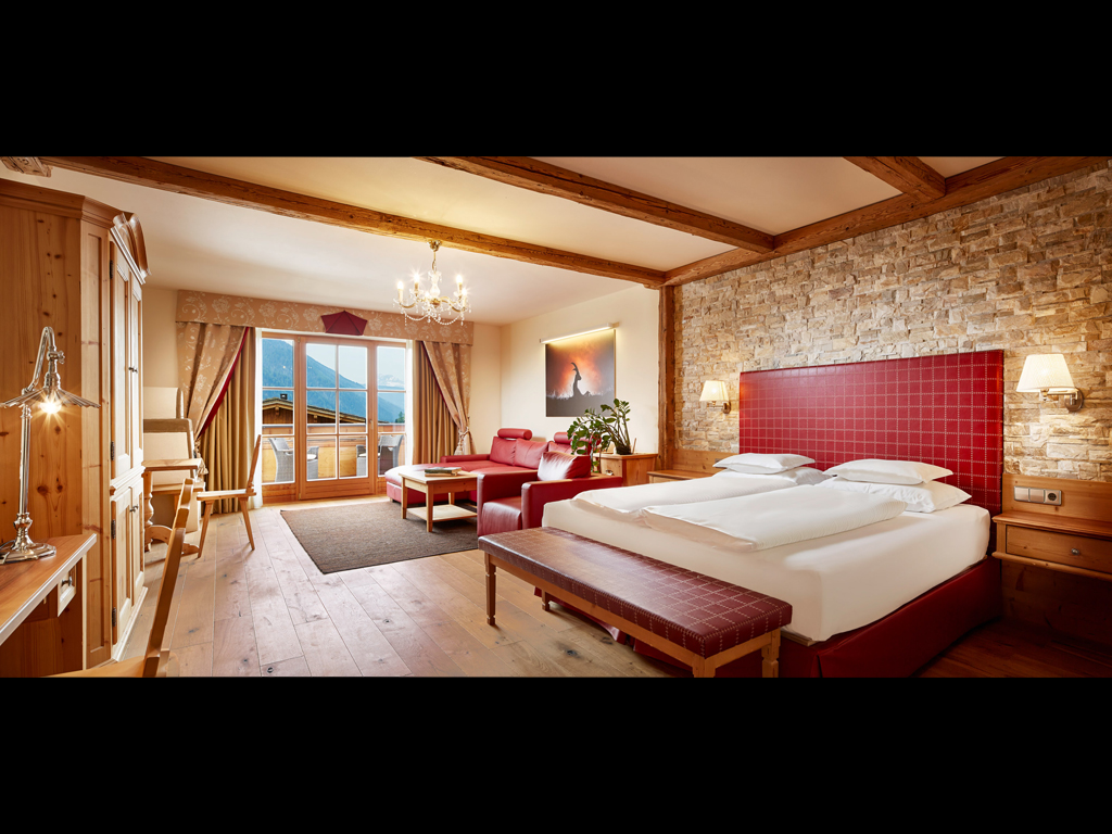 Hotel Quelle Nature Spa Resort. La Suite Bio Alpina (65mq), un vero “Chalet alpino”. Arredo di montagna, stufa rustica e balcone rivolto a sud con vista sulle Dolomiti.