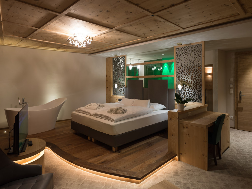 Green Lake Hotel Weiher. La Suite Green con ampio letto matrimoniale, la vasca in camera e un terrazzo con vista sul laghetto dell’hotel.