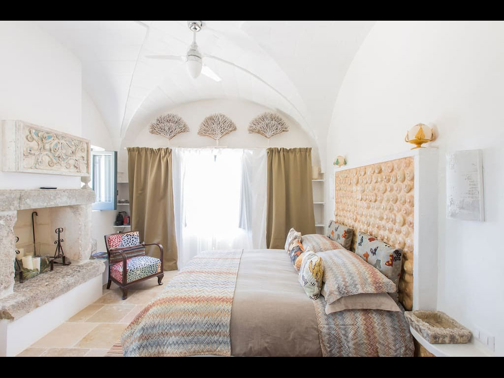 Tenuta del Lauro. Valle d'Itria, Locorotondo. Puglia. Le Suite Trullo, nell’immagine la Suite Roseto, prendono il nome dalle piante presenti nel giardino riservato. Tutte le mattine viene servita la colazione all'ombra di un pergolato di uve.