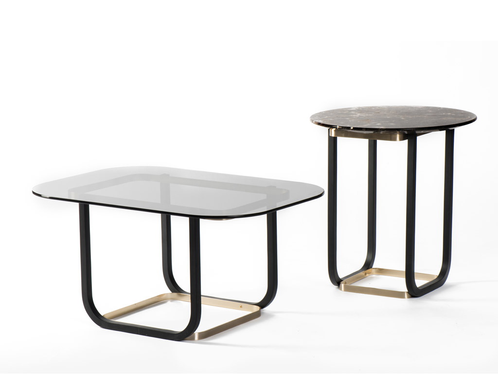 Gebrüder Thonet Vienna GTV. Tavolini Duet (2017), design Cristian Mohaded, sono presentati nella versione alta e bassa. Le gambe in legno di faggio curvato a sezione quadrata si legano alle basi in acciaio ottonato. Il top rettangolare è disponibile in vetro nero fumé ed in marmo.
