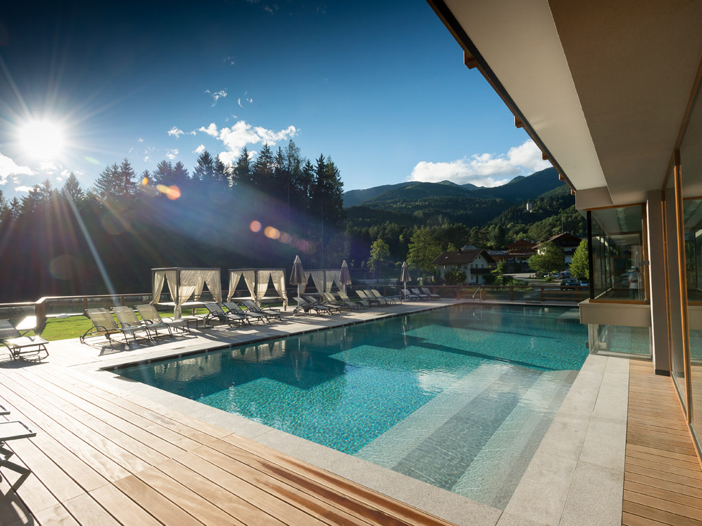 Green Lake Hotel Weiher. L’elemento acqua ha un ruolo molto importante in tutta la struttura. La piscina che si articola all'interno e all'esterno dell’hotel ha una superficie di 200 mq. con funzione idromassaggio.