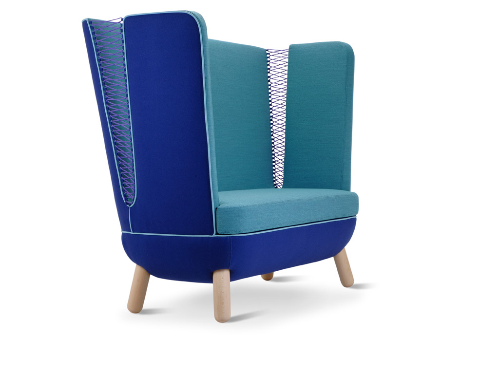 Adrenalina. Poltrona Sly. Design Italo Pertichini. Sia nella versione con lo schienale alto, nell'immagine, sia con lo schienale basso sono presenti due piccole “finestre magiche” chiuse con corde colorate intrecciate. La struttura è in legno.