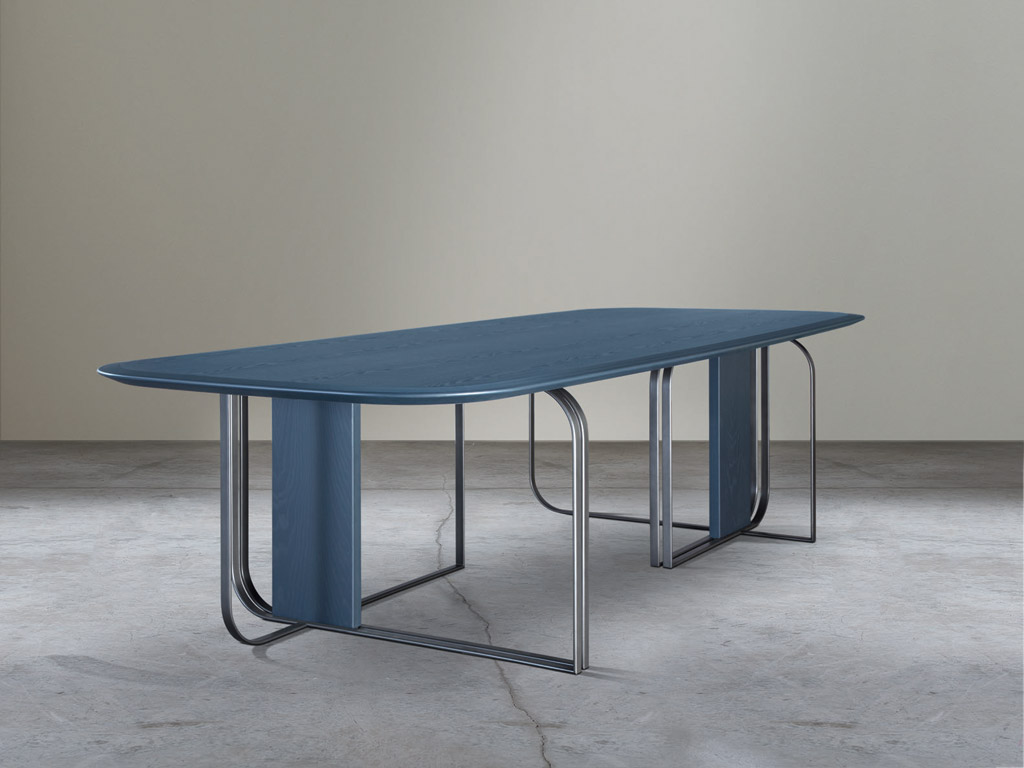 Adele-C. Composta da sedia, poltroncina e tavoli, la collezione “Bon Ton” progettata dallo Studio Baldessari e Baldessari, nasce dalla sapiente lavorazione del legno e del metallo. Qui, Il gioco degli opposti, comune denominatore della collezione, si ritrova nel confronto tra la dimensione generosa del piano e la leggerezza della struttura, composta da anelli sagomati secondo un disegno asimmetrico, doppiati e incrociati tra loro.