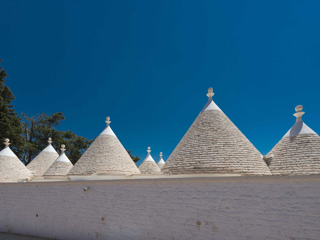 Tenuta del Lauro. Valle d’Itria, Locorotondo. Puglia. Nell'immagine gli undici coni (trulli), secolari, che con la tipica lamia costituiscono l’anima della Tenuta.