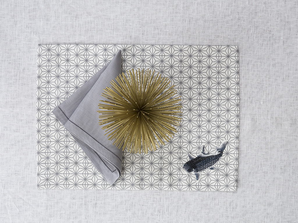 Milou Milano. “Origami Collection” è caratterizzata da una griglia elegante e delicata in bianco e grigio che decora e disegna la tavola. Per tovaglie su misura, runner e tovagliette americane da abbinare a tovaglioli in lino bianchi o grigi con orlo à jour. In limited edition anche la versione originale con patch applicati a mano: un motivo classico di pesci in grigio tono su tono.