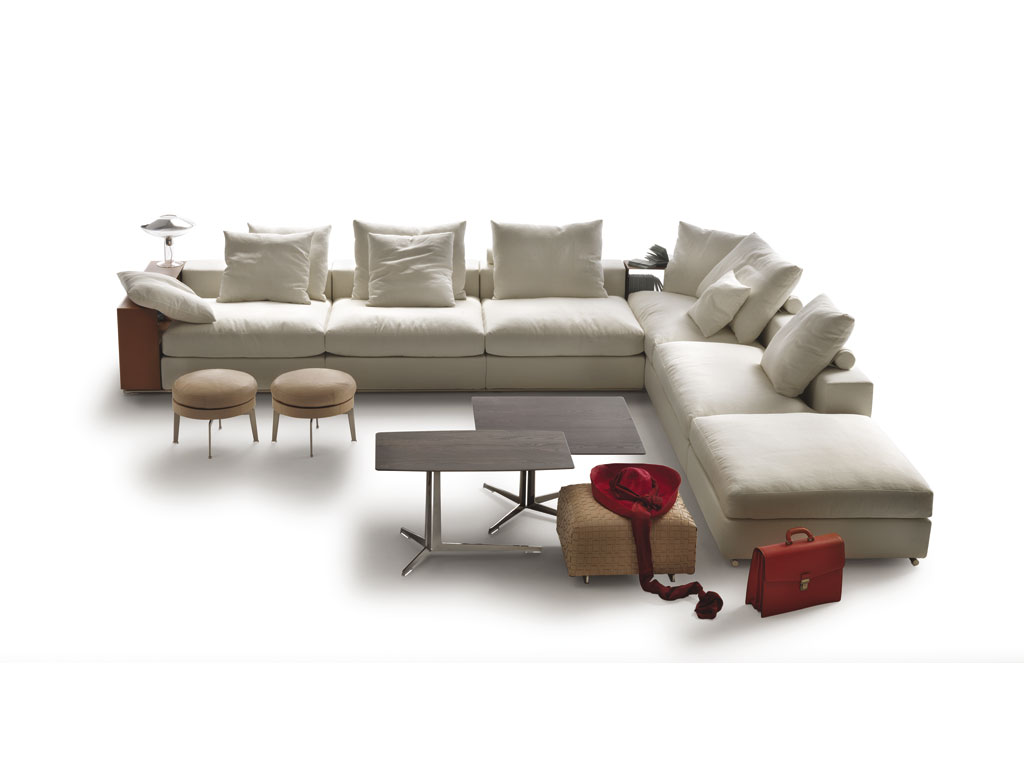 Flexform. Bestseller indiscusso, “Groundpiece” progettato dall'architetto Antonio Citterio nel 2001 ha rivoluzionato il modo di concepire il divano introducendo proporzioni e modi d’uso nuovi. Basso e profondo, destrutturato, è caratterizzato dall'inserimento di alcuni elementi-contenitore in metallo rivestito in cuoio che sostituendo parte dello schienale o del bracciolo, diventano utili piani di appoggio.