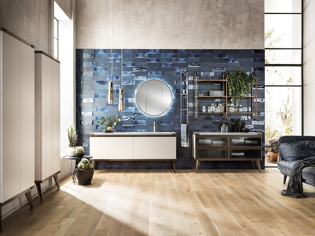 Scavolini Bagno. Nell’immagine, ambiente bagno arredato con il programma Diesel Open Workshop di Scavolini, realizzato in collaborazione con Diesel. Un sistema di contenimento davvero ricco per l'ambiente bagno: coppia di armadi a parete con profondità 20 cm, presentati in Decorativo Soft Beige – la stessa delle ante sotto lavabo. Contenere è la parola d’ordine anche per gli elementi più piccoli: la specchiera Lunar Stock– qui proposta laccata in finitura Bronzo – diventa un perfetto “nascondiglio” per i prodotti di bellezza e cura della persona. Il Sistema a parete Stock Rack rivela strutture verticali in finitura Bronzo.