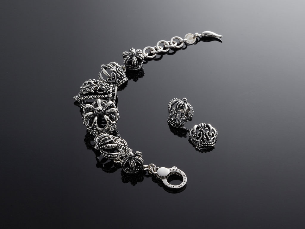 Giovanni Raspini. Collezione The Queen si declina in tre collane, due bracciali, un orecchino e un anello. I pezzi sono realizzati in fusione di argento con finitura brunita. Creazioni riconoscibili e importanti. Collezione Primavera Estate 2018.