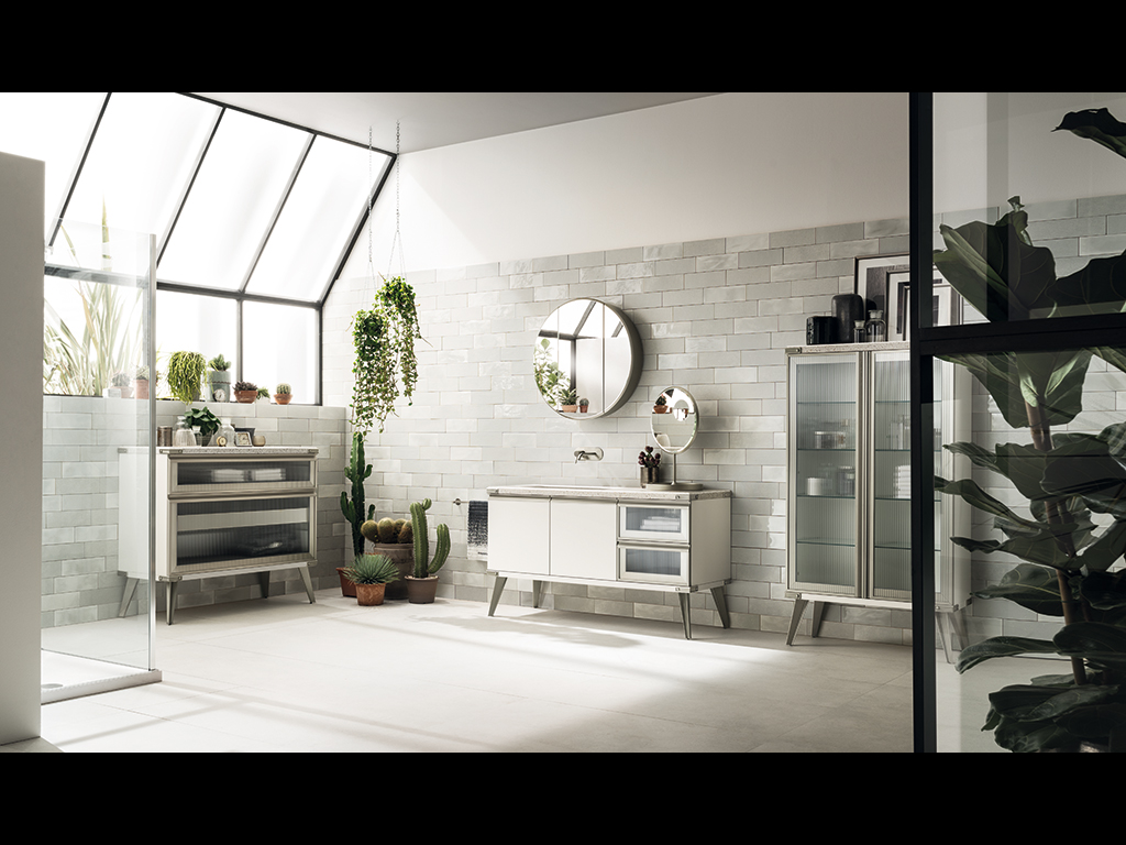 Scavolini Bagno. Nella foto, ambiente bagno arredato con il programma Diesel Open Workshop di Scavolini, realizzato in collaborazione con Diesel. Una composizione “total white” che sottolinea le diverse altezze degli elementi della collezione, esaltando la varietà compositiva dello spazio verticale. Al centro mobile con lavabo “Shape” in ceramica bianca sottopiano, basi di altezza 50 cm e top Quarz Motley. I profili, i piedi sono in finitura Acciaio Soft, le ante piane in Laccato Opaco Bianco Prestige e le ante telaio Acciaio Soft con vetro Ribbed Glass. Sulla destra vetrinetta con ante telaio Acciaio Soft con vetro Ribbed Glass di altezza 125 cm; a sinistra la grande base con anta vetro e cassettiera interna di altezza 75 cm.