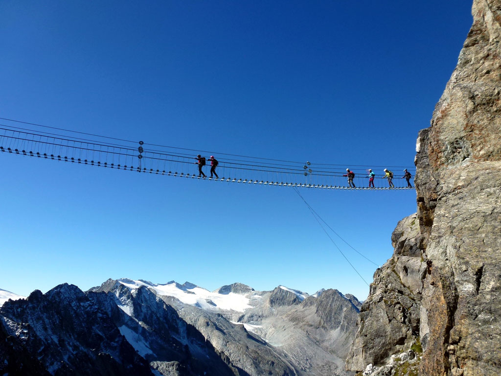 Val di Sole. La via ferrata Il Sentiero dei Fiori, molto esposto nel Gruppo dell'Adamello-Presanella, è un itinerario impegnativo ma di eccezionale interesse paesaggistico e storico. Ad un'altitudine di 3.000 metri, sulle impervie creste tra il Pisgana e il Castelaccio, antica linea di confine con l'Austria, il sentiero si articola tra arditi amminamenti, le gallerie e i trinceamenenti della prima linea italiana ai tempi della Grande Guerra. Ricostruite, con l'aiuto di vecchie fotografie, due passerelle sospese di 55 e 75 metri di lunghezza. (Ph. I Menapace)