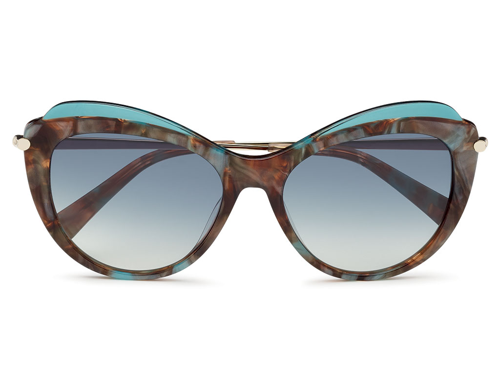 Longchamp Paris. Di forma Cat-Eye, questo modello presenta un frontale in acetato marmorizzato scolpito con uno strato superiore trasparente, il caratteristico emblema del cavallo in metallo e una cerniera che si ispira ai dettagli dell’iconica borsa Roseau della Maison.