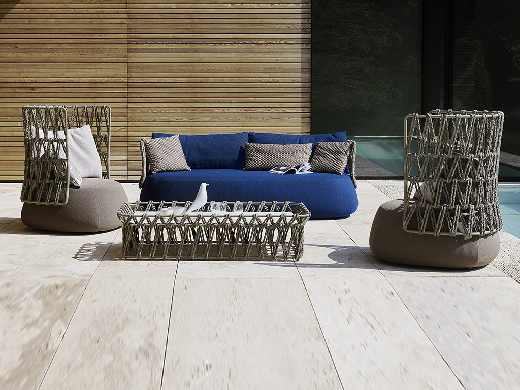 B&B Italia Outdoor. Le forme morbide e sinuose, del sistema di sedute “Fat-Sofa”, disegnato da Patricia Urquiola, vengono riprese nella versione da esterni. La seduta completamente imbottita è accompagnata ad uno schienale con struttura in metallo su cui si tesse l'originale intreccio (realizzato con fibre di polietilene ritorte di color tortora) creando uno speciale gioco di pieni e vuoti.