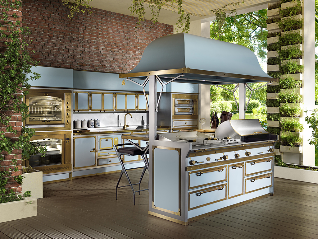 Officine Gullo. “Pacific Light Blue” è una nuova cucina da esterno in acciaio verniciato a fuoco con finiture in ottone brunito. Si compone di un’isola cottura centrale equipaggiata di doppio barbecue, maxi bruciatore ad alto rendimento con potenza pari a 10 kW, e doppio fry-top liscio/rigato munito di coperchio in acciaio. La zona lavaggio è dotata di lavello a vasca singola e di produttore di ghiaccio professionale. Adiacenti, due colonne munite di forno multifunzione, doppio forno pizza, girarrosto e scaldavivande. Completano l’ambiente gli sgabelli in fusione di alluminio con rivestimento in pelle cucita a mano.