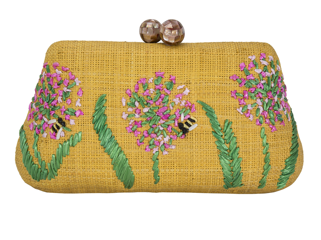 Rafe New York. La clutch “Rosie” è realizzata in paglia di abaca e presenta ricami fatti a mano, fermagli a conchiglia, una catenella e una divertente fodera a quadretti.