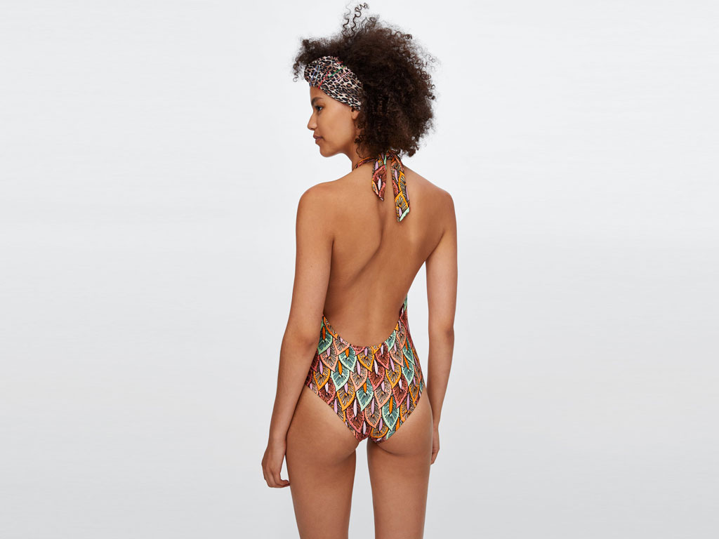 Zara. Costume modello “Halter” con fiocco e stampa a foglie multicolor. Scollo pronunciato e fodera interna a contrasto.