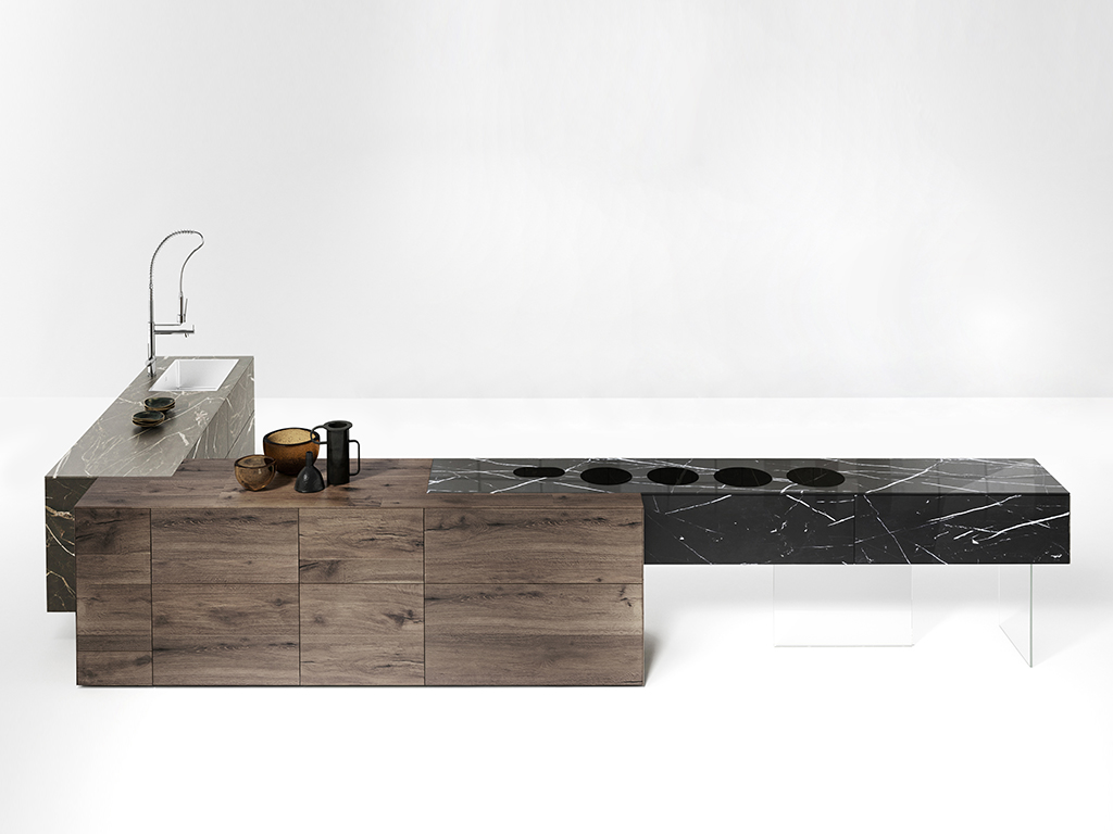 Lago. Cucina 36e8 Fusion, design Daniele Lago. Tre blocchi compatti si compenetrano perfettamente creando un contrasto cromatico e materico. Al centro una base in legno Wildwood, un rovere antico con venature tridimensionali, a cui si intersecano massicci blocchi in vetro che richiamano la texture del marmo, resi leggeri dalla sospensione su gambe in vetro extrachiaro temperato. Modulabile per composizioni a isola o a parete, lineari o ad angolo. Disponibile nelle tinte: calacatta gold, calacatta black e marquina (misure: L. 540 cm e P 280 cm.).