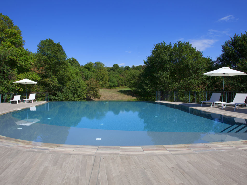 Isola Verde Piscine. Uno specchio d’acqua di forma organica nasce lungo il declivio del prato come fosse un piccolo lago immerso nel verde. È la piscina del Golf Club Colli Berici, rientrata nel quadro di una ristrutturazione totale del complesso. Progettista: architetto Franco Albanese.