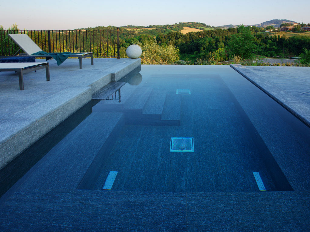 Itaca. Sempre la piscina delle immagini precedenti. In primo piano l’area dedicata all’idromassaggio. Al suo interno si trovano: tre postazioni idromassaggio aria-acqua (schiena - polpacci); due postazioni idromassaggio aria (piante dei piedi); una postazione idromassaggio Dinamik; tre fari RGB.