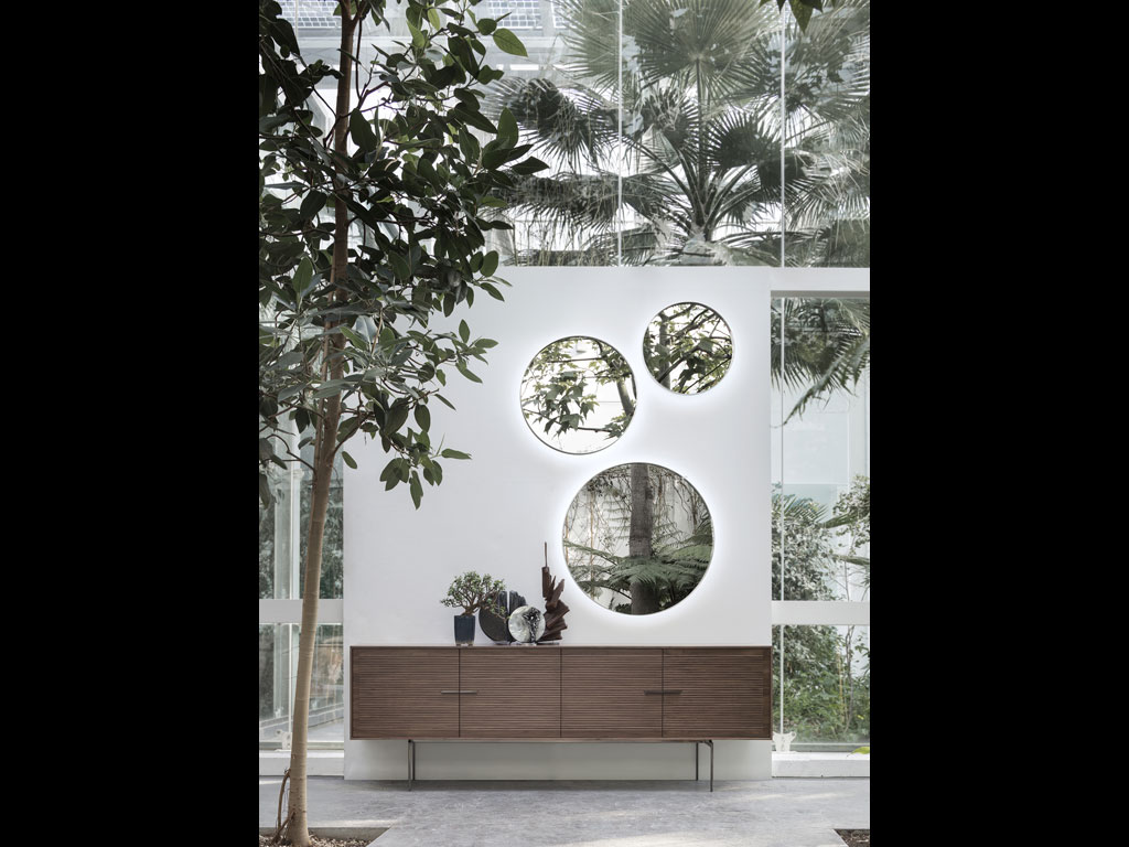 Alivar. Collezione Home Project. Design Giuseppe Bavuso. Il nuovo specchio “Face To Face” con cornice rotonda in acciaio inox verniciato si completa sul retro di illuminazione a LED. Ai piedi la nuova credenza “Galatea” con vani contenitori chiusi e interni in MDF laccato opaco. La struttura è sostenuta da gambe in fusione di alluminio verniciato.