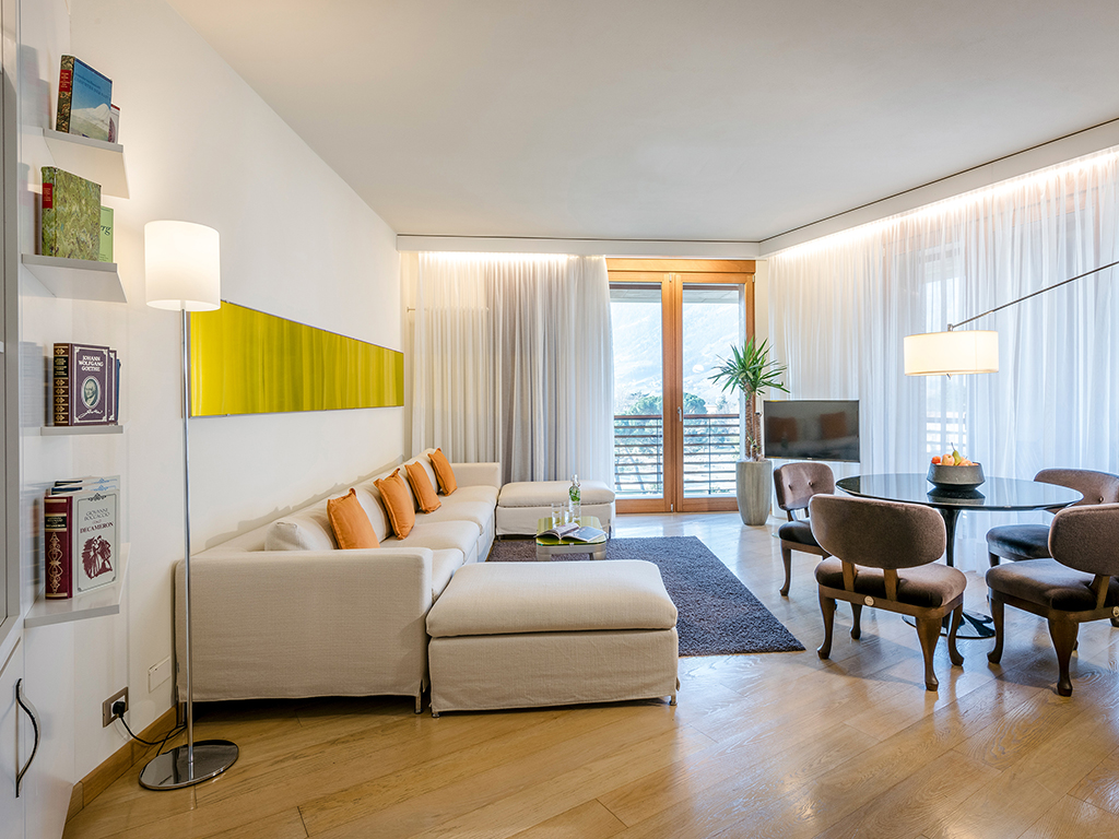 Hotel Terme Merano. Le Calla Suite, sono tre in tutta la struttura, di circa 60 mq. godono di una vista spettacolare sul Parco delle Terme, il centro storico di Merano o sulle Valli circostanti. L’ospitalità include l’utilizzo della Sky Spa, della Garden Spa dell’Hotel e l’entrata libera alle Terme di Merano. Nell’immagine il salotto.
