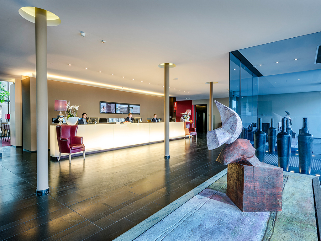 Hotel Terme Merano. La Hall dell’hotel, nell’immagine, è un intreccio di forme e colori dallo stile moderno ma con un forte richiamo allo storia dell’Alto Adige.