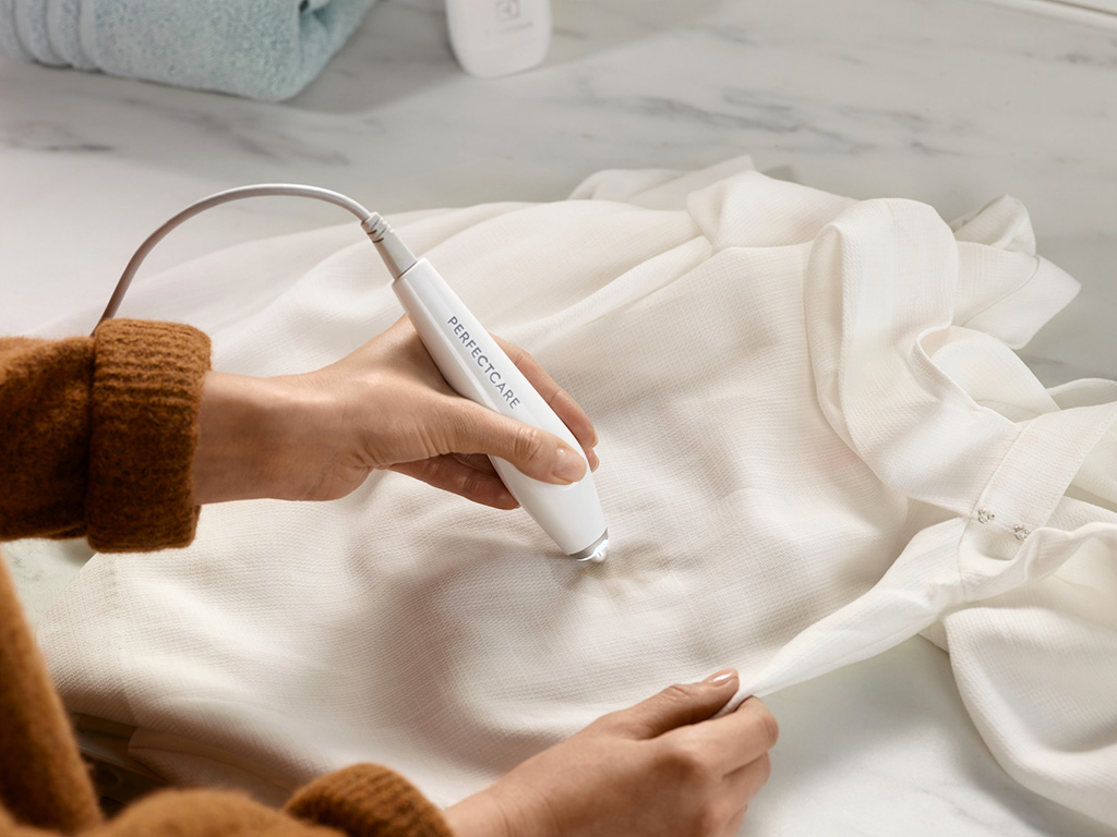 Electrolux. Basta bagnare la macchia con un po' d’acqua e detersivo liquido incolore e poggiare la penna smacchiante Ultrasonic PerfectCare sul tessuto per far sì che la tecnologia a ultrasuoni sciolga efficacemente la macchia. La combinazione di acqua, detergente e tecnologia a ultrasuoni trasmette migliaia di micro-vibrazioni al secondo alle fibre dei tessuti, sciogliendo le singole particelle delle macchie, fino a farle scomparire del tutto, senza lasciare aloni. Dopo il trattamento, si consiglia di risciacquare la zona trattata e lasciare asciugare, per avere il capo come nuovo in pochi minuti.