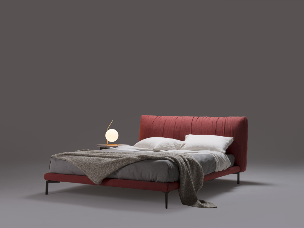My Home Collection. Morbido e accogliente il letto “Moon” esalta le attitudini sensoriali della pelle e del tessuto che vengono lavorati in modo da offrire una piacevole sensazione di agio e sofficità. Testata e giroletto sono in legno rivestiti in gomma poliuretanica e fodera in fibra di poliestere. Gambe in acciaio verniciato. Rete con doghe di faggio. Progetto: Angeletti Ruzza design.