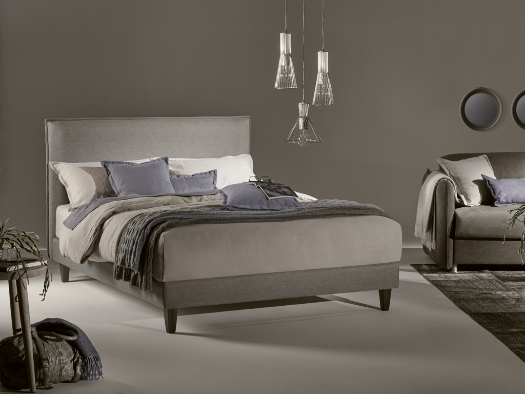 Dorelan My Bed. Sommier Play. La testiera Lord Home racchiude una morbida imbottitura in una struttura con disegno rettangolare che richiama la forma e l’accoglienza di un grande cuscino. Impreziosiscono le cuciture decorative perimetrali. Il rivestimento è previsto fisso e sfoderabile velcrabile con sistema di aggancio a baionetta per sommier o predisposizione a muro. Altezza fascia: 100/120 cm.