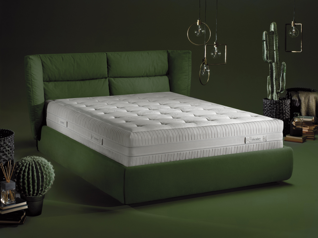 Dorelan. Sandi. Designer Samuel Accoceberry. Linea Lab_style. Il letto Sandi è la nuova stella dell’azienda. Confortevole grazie ad una testiera avvolgente dalle preziose imbottiture, accogliente, soffice e un design armonioso ed elegante. La struttura in agglomerato di legno preforata per l’assemblaggio. Le imbottiture sono in poliuretano espanso rivestite in bianco con vellutina nylon accoppiato a fibre poliestere e vellutino nylon stampato “Dorelan”. Realizzabile anche su misura. Completamente sfoderabile e dotato di contenitore, il letto ospita materassi di dimensioni L160xP190/200cm e L180xP190/200. Nella foto il materasso Koral a sostegno rigido con molleggio Twin System.