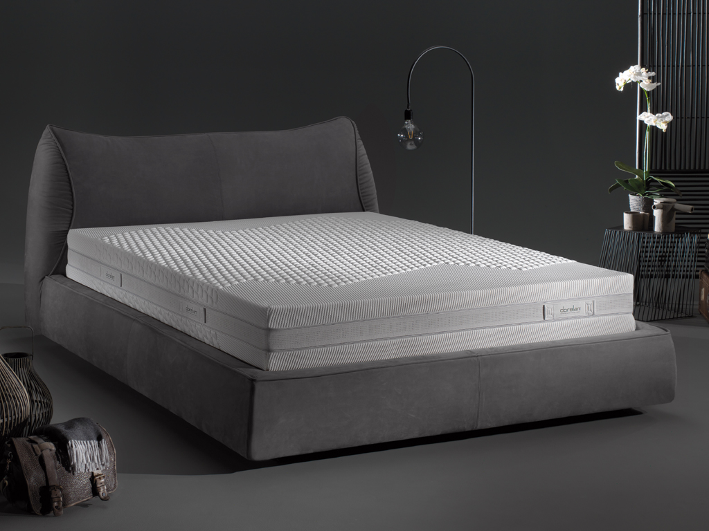 Dorelan. Smooth. Designer Enrico Cesana. Linea Metropolitan_life. La morbidissima testiera è la protagonista di questo letto dai volumi sinuosi e ricercati, design leggero e dettagli sartoriali. La struttura in agglomerato di legno preforata per l’assemblaggio. Le imbottiture sono in poliuretano espanso rivestite in bianco con vellutina nylon accoppiato a fibre poliestere e vellutino nylon stampato “Dorelan”. Realizzabile anche su misura. Completamente sfoderabile e dotato di contenitore, Smooth ospita materassi di dimensioni L160xP190/200cm e L180xP190/200. Nella foto il materasso della linea Twin Essense completo di fodera Essense Twin priva di imbottiture.