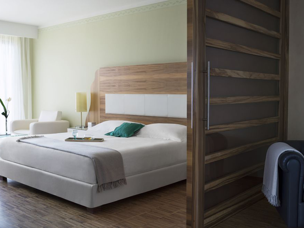 Lefay Resort & SPA Lago di Garda. Letto e zona living della Exclusive Suite. La camera articolata in 83 mq. regala la libertà di un living room privato, una Jacuzzi vista lago e di una serie di servizi esclusivi.