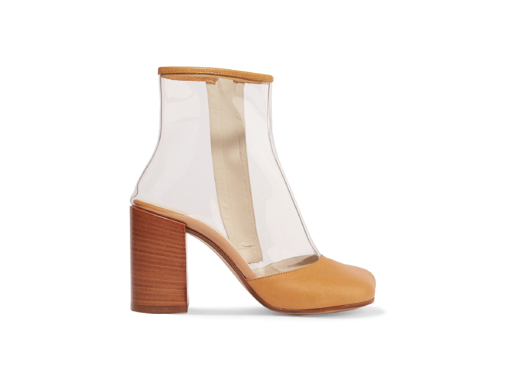 Maison Margiela. Sono montati su un tacco di legno, gli stivaletti MM6. Realizzati in PVC trasparente hanno la punta in pelle stampata. Da indossare con orli tagliati o midi.