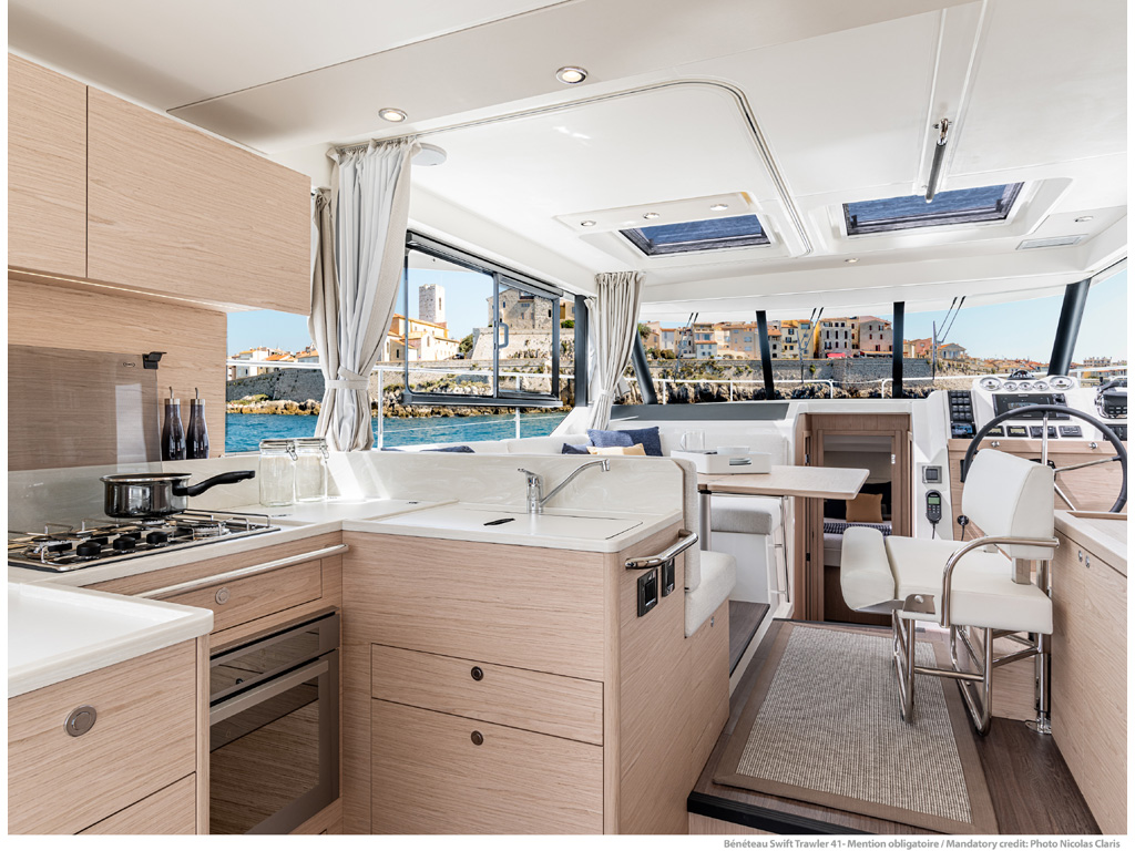 Bénéteau. Swift Trawler 41. Gli interni sono molto luminosi, accoglienti e funzionali. La cucina è posizionata verso poppa n collegamento diretto con il pozzetto che dispone di un divanetto scorrevole che facilita il passaggio verso la piattaforma bagno. Photo Nicolas Claris.