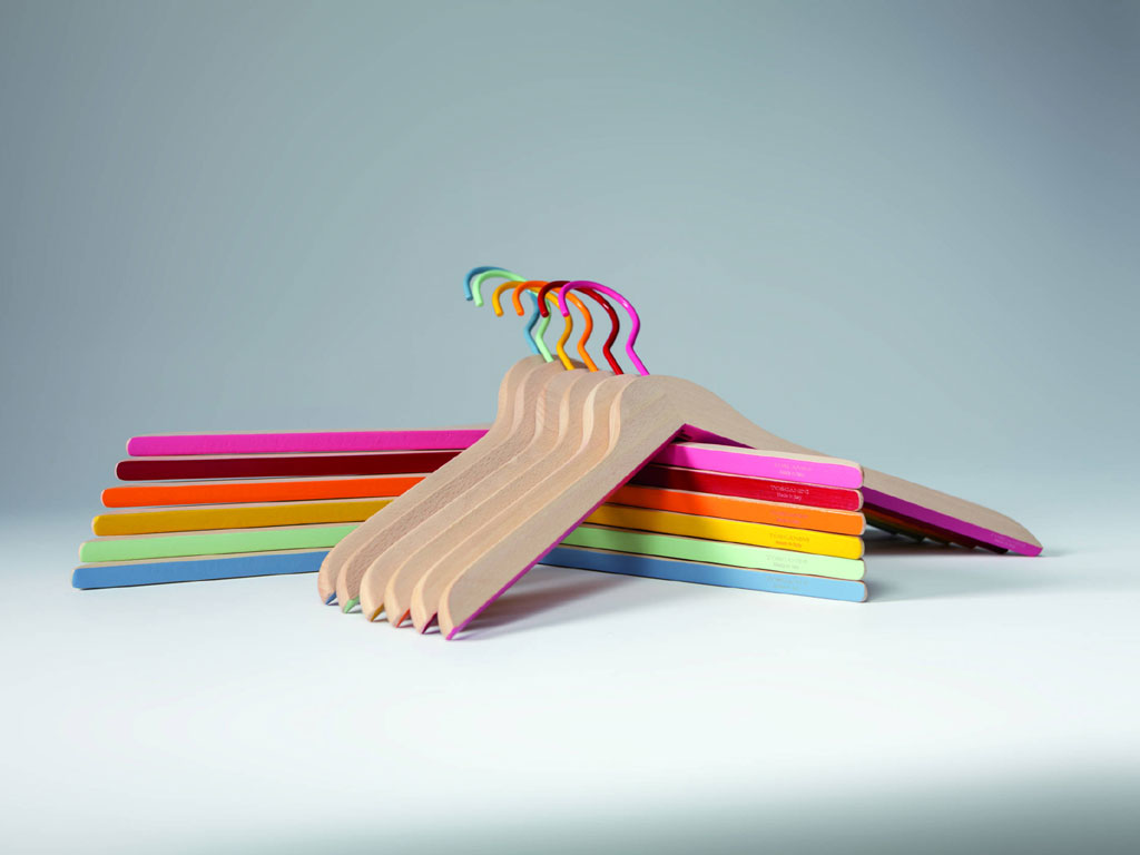 Toscanini. Linea “Confetti”. Portabiti modello “Irene” in legno di faggio non trattato, con gancio e parte inferiore colorati. Sono pensati per aggiungere un tocco pop al guardaroba. Proposti in una sola misura (cm 43 x 1.2) e nei colori: arancione, red cherry, fucsia e dusty blue, giallo intenso, verde menta. Disponibili online in confezione da 9 pezzi a Euro 43,90.