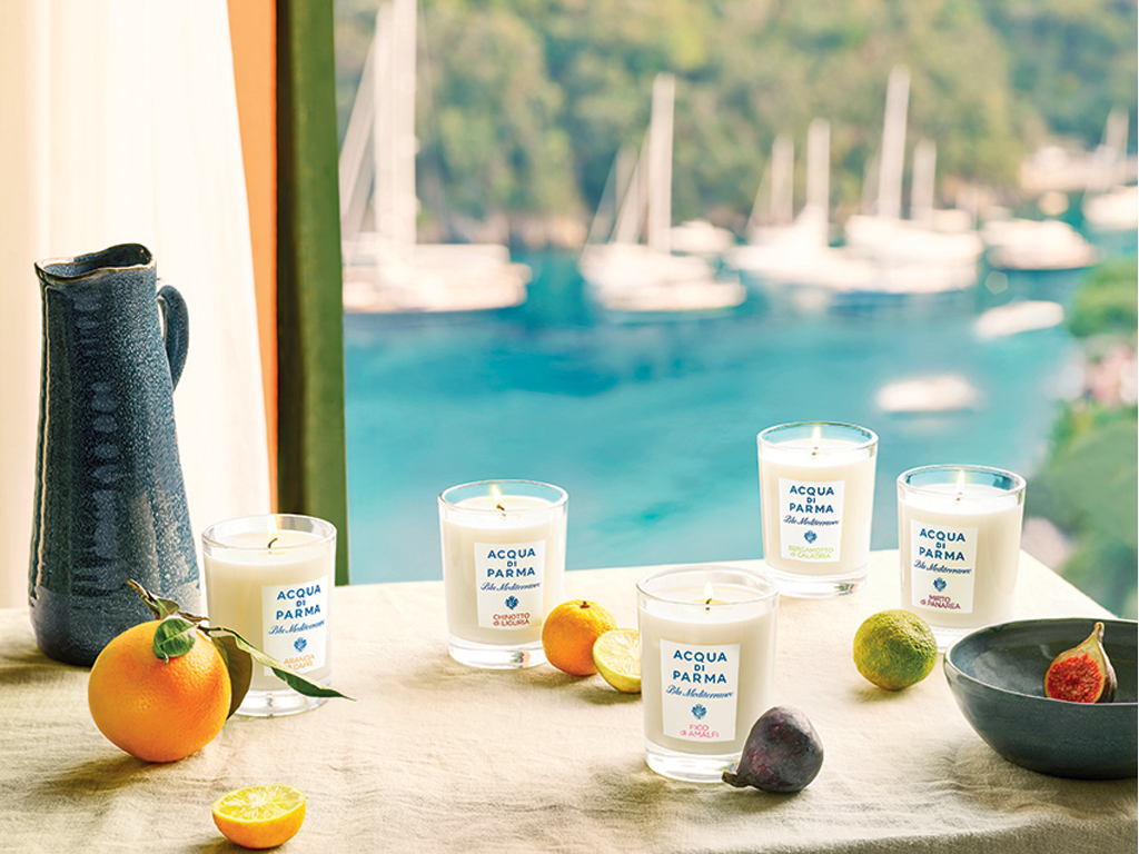 Acqua di Parma. Home Collection. Blu Mediterraneo. Vetro trasparente per le candele e tappo in urea bianco e bastoncini in rattan naturale. Packaging e dettagli richiamano il blu del mare. Le essenze: Arancia di Capri, Fico di Amalfi Chinotto di Liguria, Bergamotto di Calabria e Mirto di Panarea. Candela, euro 54,00. Diffusore euro 65,00.