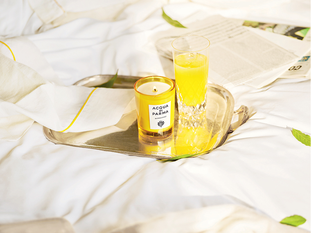 Acqua di Parma. Home Collection. Buongiorno. Proposto nella versione candela nel bicchiere da 200gr e diffusore da 180ml. Il bicchiere, realizzato con uno stampo esclusivo, riproduce il flacone Art Déco di Colonia. Mentre il diffusore, sempre dalle linee Art Déco, completa il proprio design con l’iconico tappo e i bastoncini in rattan. Candela, euro 54,00. Diffusore euro 65,00.