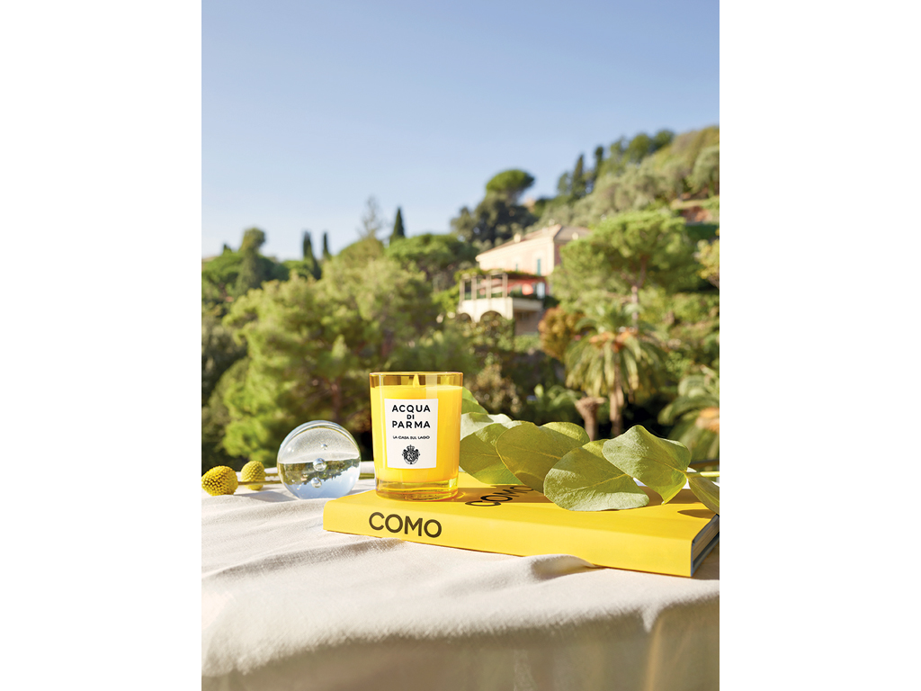Acqua di Parma. Home Collection. La Casa sul Lago. Proposto nella versione candela nel bicchiere da 200gr e diffusore da 180ml. Il bicchiere, realizzato con uno stampo esclusivo, riproduce il flacone Art Déco di Colonia. Mentre il diffusore, sempre dalle linee Art Déco, completa il proprio design con l’iconico tappo e i bastoncini in rattan. Candela, euro 54,00. Diffusore euro 65,00.