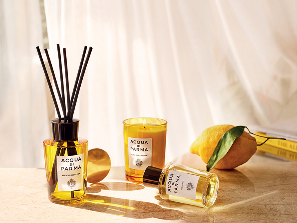 Acqua di Parma. Home Collection. Luce di Colonia. Proposto nella versione candela nel bicchiere da 200gr e diffusore da 180ml. Il bicchiere, realizzato con uno stampo esclusivo, riproduce il flacone Art Déco di Colonia. Mentre il diffusore, sempre dalle linee Art Déco, completa il proprio design con l’iconico tappo e i bastoncini in rattan. Candela, euro 54,00. Diffusore euro 65,00.