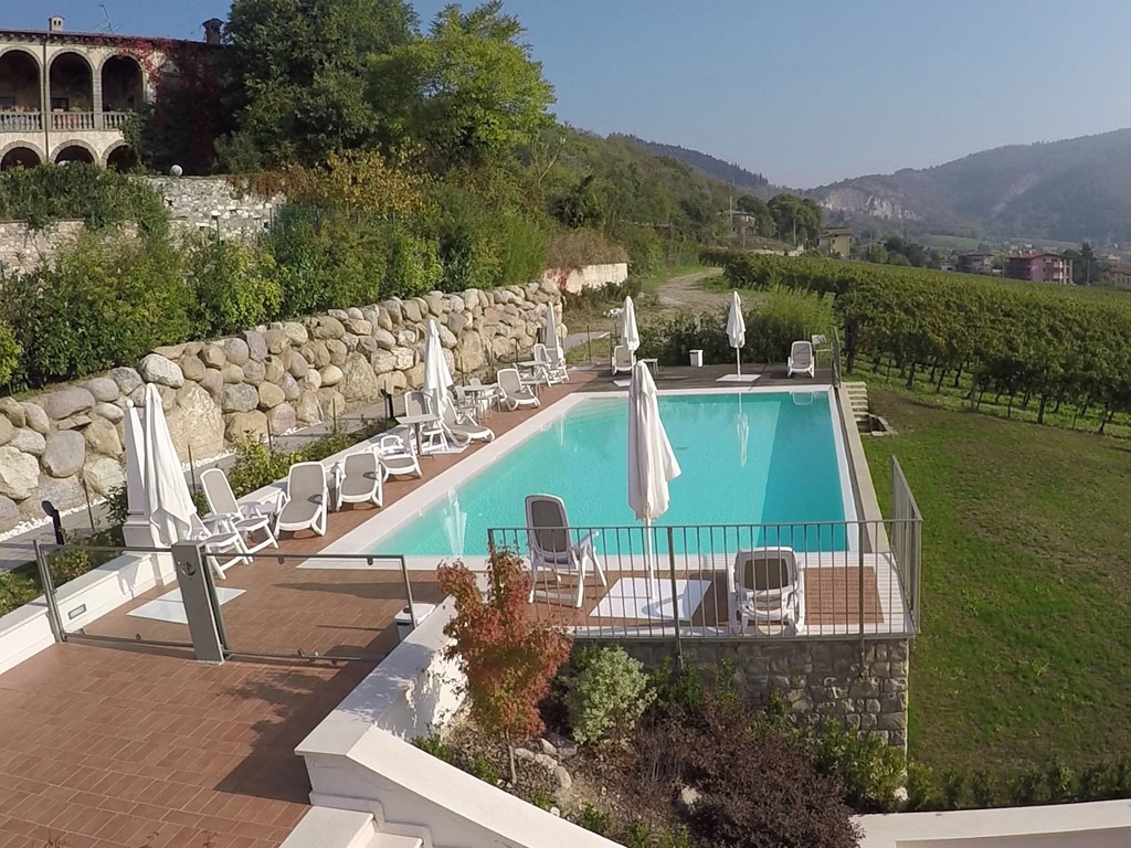 Agriturismo Corte Lantieri. Tra grandi terrazze e giardini fioriti spicca affacciata sui filari la piscina.