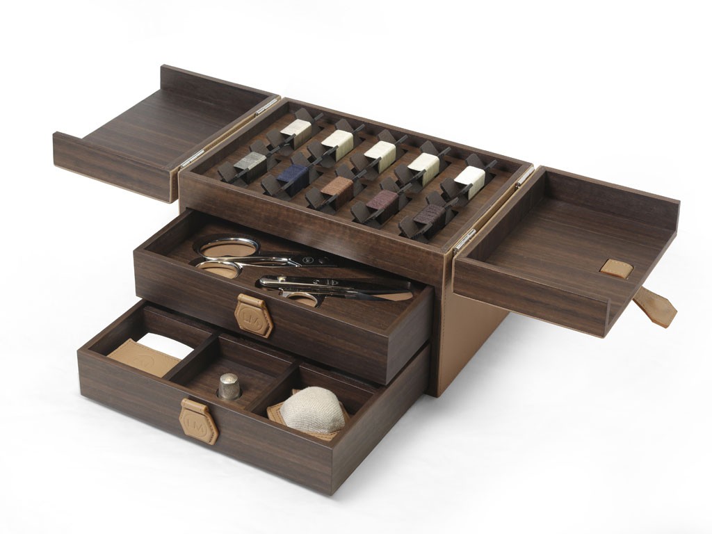 Ludovica Mascheroni. Kit per il cucito. All’interno: puntaspilli, aghi, ditale, rocchette in legno con fili di diversi colori, forbici da cucito, metro in pelle, gesso da sarto. Qui nella versione Noce canaletto ed eucalipto, rivestito in pelle. Cerniere in ottone palladio e maniglie in pelle.